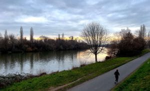 A woman running along the river Main in Germany at dusk